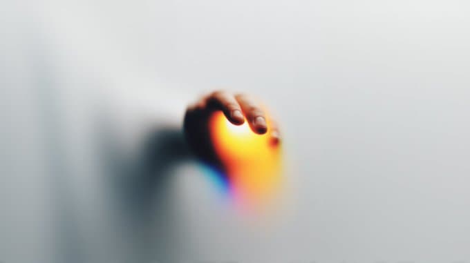 A hand holding a blurred beam of light